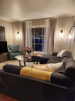 a living room with a couch and a table at Idyllic Snekkerstuvarpet with its own pier in Lillehammer