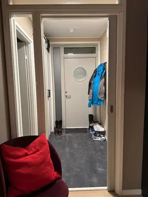 a room with a door with a red blanket and a chair at 3-room downtown apartment in Trondheim
