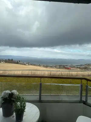 a balcony with a table and a view of a field at 3-room downtown apartment in Trondheim