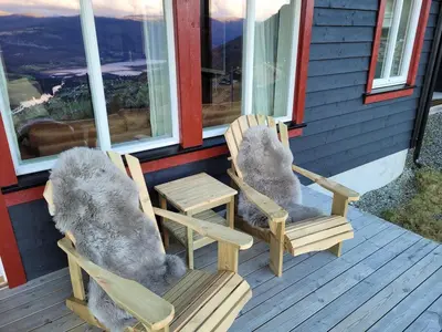 two chairs and a table on the porch of a house at Apartment Tråstølen ski in ski out in Vossevangen