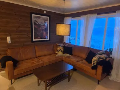 a living room with a brown couch and a table at Apartment Tråstølen ski in ski out in Vossevangen