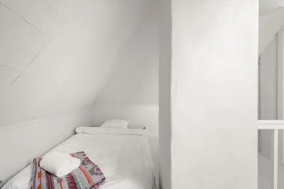 a white room with a bed with towels on it at Bergen Gem Straight Out of History - Built in 1750 in Bergen