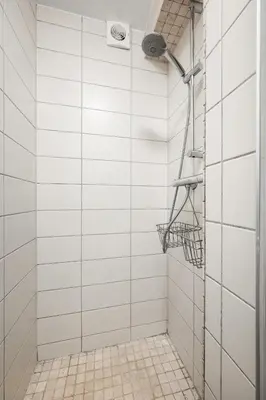 a bathroom with a shower with white tiled walls at Bergen Gem Straight Out of History - Built in 1750 in Bergen