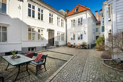 a patio with a table and chairs in the middle of buildings at Bergen Gem Straight Out of History - Built in 1750 in Bergen