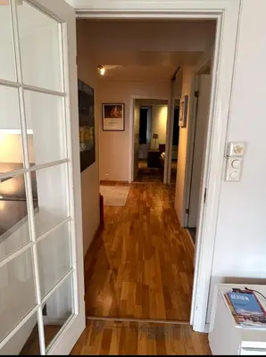 a hallway leading into a living room with a hard wood floor at Nice appartment in Bergens best location in Bergen