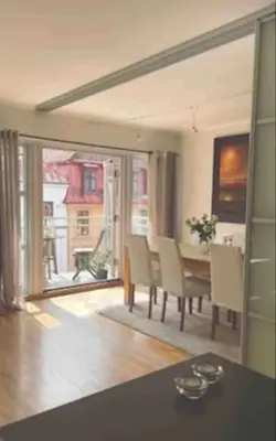 a living room with a table and chairs and a large window at Nice appartment in Bergens best location in Bergen