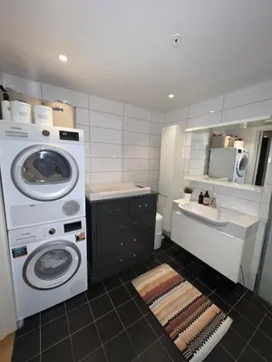 a bathroom with a washing machine and a sink at Centrally located apartment in Bergen
