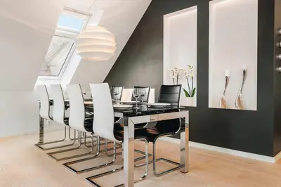 a dining room with a black table and white chairs at DINBNB Apartments l Luxury Penthouse l Roof Terrace l Central Bergen in Bergen