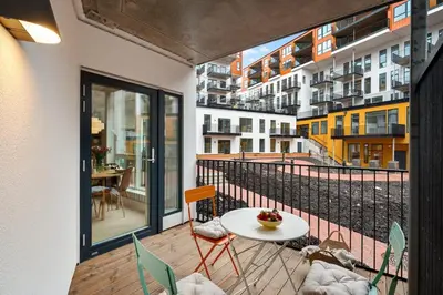 a balcony with a table and chairs and a view of a city at Helt ny leilighet Ytre Sandviken in Bergen