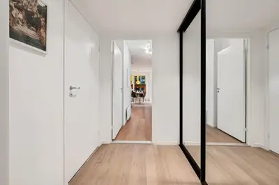 a mirror in a hallway with white walls and wooden floors at Helt NY leilighet, Ytre Sandviken i Bergen in Bergen
