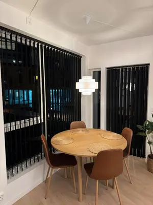 a dining room with a table and chairs and large windows at Helt NY leilighet, Ytre Sandviken i Bergen in Bergen