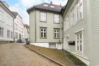 a green house on the side of a street at Bergen Beds - Modern, Cozy & Perfect Location in Bergen