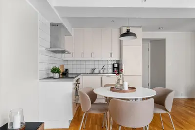 a white kitchen with a table and chairs at Bergen Beds - Modern, Cozy & Perfect Location in Bergen