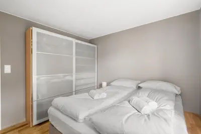 a white bed with white sheets and pillows on it at Bergen Beds - Modern, Cozy & Perfect Location in Bergen