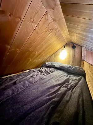 a bed in a room with a wooden ceiling at The Heritage Lodge - Geilo in Geilo