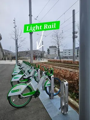 a row of green bikes parked next to a light rail sign at Home is where your heart is! in Bergen