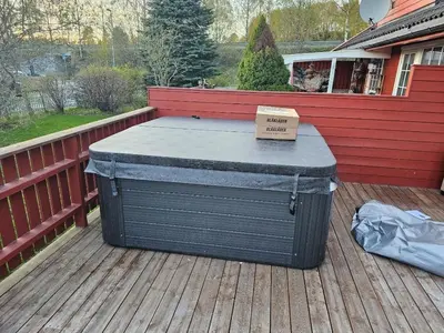 a hot tub sitting on a deck with a sign on it at Hus i Verdal med 3 soverom in Verdal