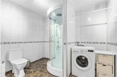 a bathroom with a shower and a washing machine at Hus i Verdal med 3 soverom in Verdal