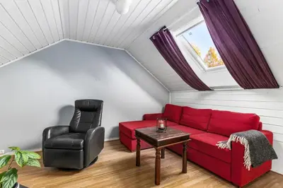a living room with a red couch and a chair at Hus i Verdal med 3 soverom in Verdal