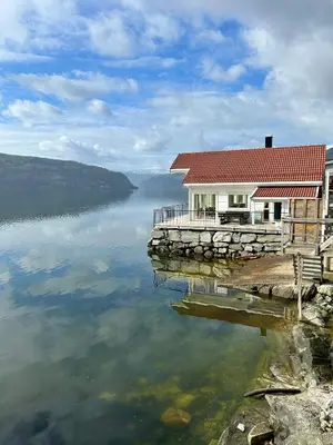 a house on a dock on a body of water at Stryn Fjord Lodge Faleide in Stryn