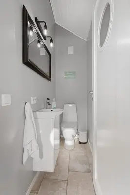 a bathroom with a toilet and a sink and a mirror at Stryn Fjord Lodge Faleide in Stryn