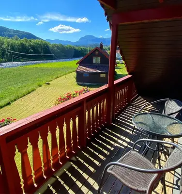 a balcony with chairs and a table and a house at Mo Laksegard in Sand