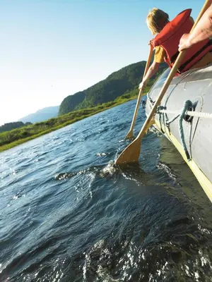 a person is rowing a boat in the water at Mo Laksegard in Sand
