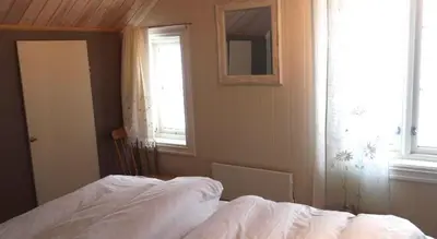 a bedroom with a bed and a window at Jordbærstova Feriehus in Valldal