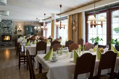 a dining room with white tables and chairs at Jordbærstova Feriehus in Valldal