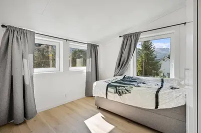 a bedroom with a bed and large windows at Large single-family home - Central in Voss in Vossevangen