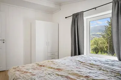 a bedroom with a bed and a large window at Large single-family home - Central in Voss in Vossevangen