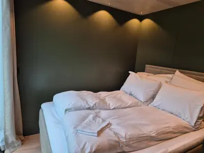 a bed with white sheets and pillows on it at Hytte Grøtdalstind, Rekkedal Gjestegard - Sæbø in Sæbø