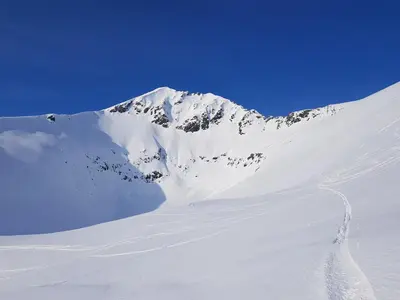 a snow covered mountain with a trail in the snow at Hytte Blåtind, Rekkedal Gjestegard - Sæbø in Sæbø
