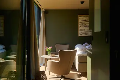 a room with two chairs and a table and a bed at Hytte Blåtind, Rekkedal Gjestegard - Sæbø in Sæbø