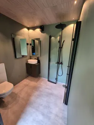 a bathroom with a toilet and a sink and mirror at Hytte Blåtind, Rekkedal Gjestegard - Sæbø in Sæbø