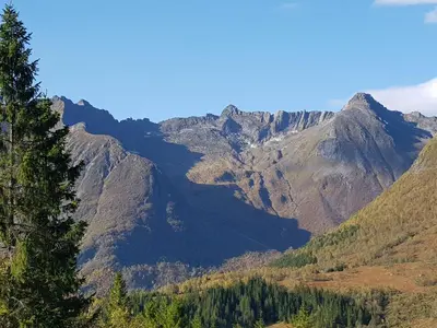 a view of a mountain range with trees in the foreground at Hytte Blåtind, Rekkedal Gjestegard - Sæbø in Sæbø