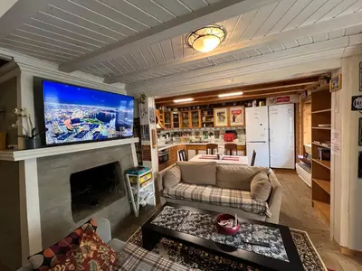 a living room with a couch and a large screen tv at Knirkenheimen in Trondheim