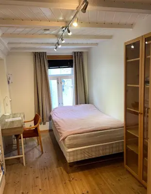 a bedroom with a bed and a desk and a table at Knirkenheimen in Trondheim