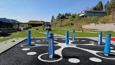 a playground with blue and white poles in a park at Aurdal Fjordcamping og Hytter in Aurdal