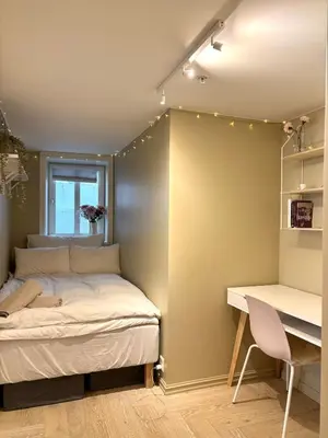 a bedroom with a bed next to a desk and a desk at Apartment behind Bryggen in Bergen in Bergen