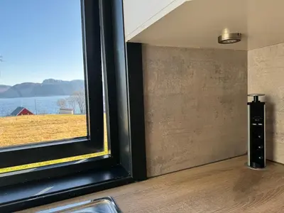 a room with a window with a view of a field at New apartment by the fjord in Stadlandet