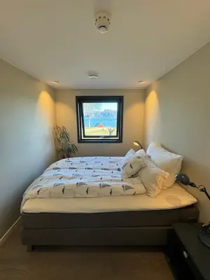 a bedroom with a bed with a window at New apartment by the fjord in Stadlandet