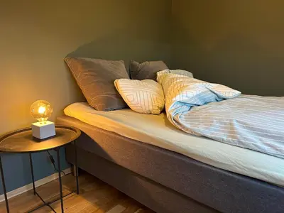 a bed with pillows on it with a side table at Pellestova Apartments in Hafjell