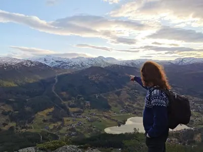 a woman standing on top of a mountain taking a picture at Kramsjø Gjestgiveri in Herand