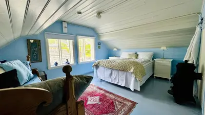 a bedroom with a bed in a blue room at Kramsjø Gjestgiveri in Herand