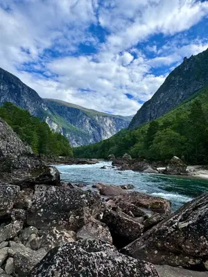 a river with rocks and mountains in the background at Bispen Villa Utsikten in Åndalsnes