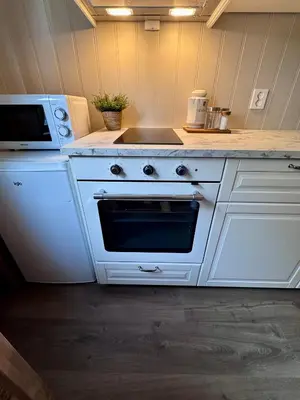 a kitchen with a white stove and a microwave at Bispen Villa Utsikten in Åndalsnes