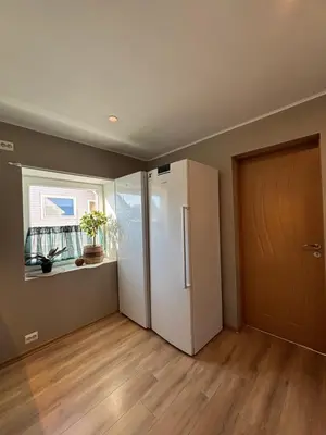 an empty room with a refrigerator and a window at Comfortable apartment in Ålesund in Ålesund