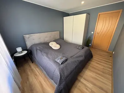 a small bedroom with a bed and a wooden floor at Comfortable apartment in Ålesund in Ålesund
