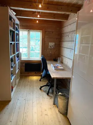 an office with a desk and a chair in a room at Stort hus med tømmervegger og fjordutsikt in Stranda